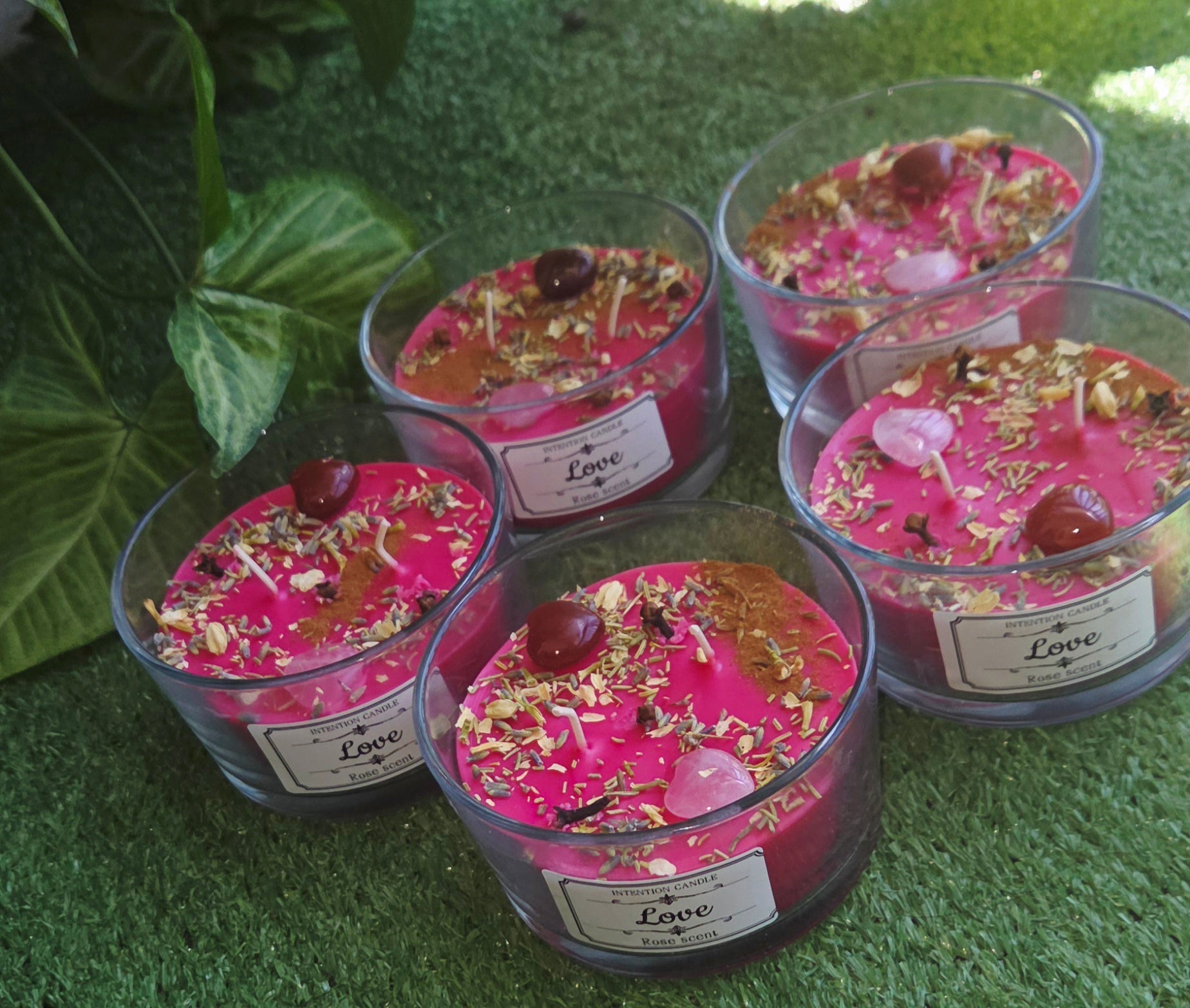 Soy wax candles in glass jars topped with herbs and crystals