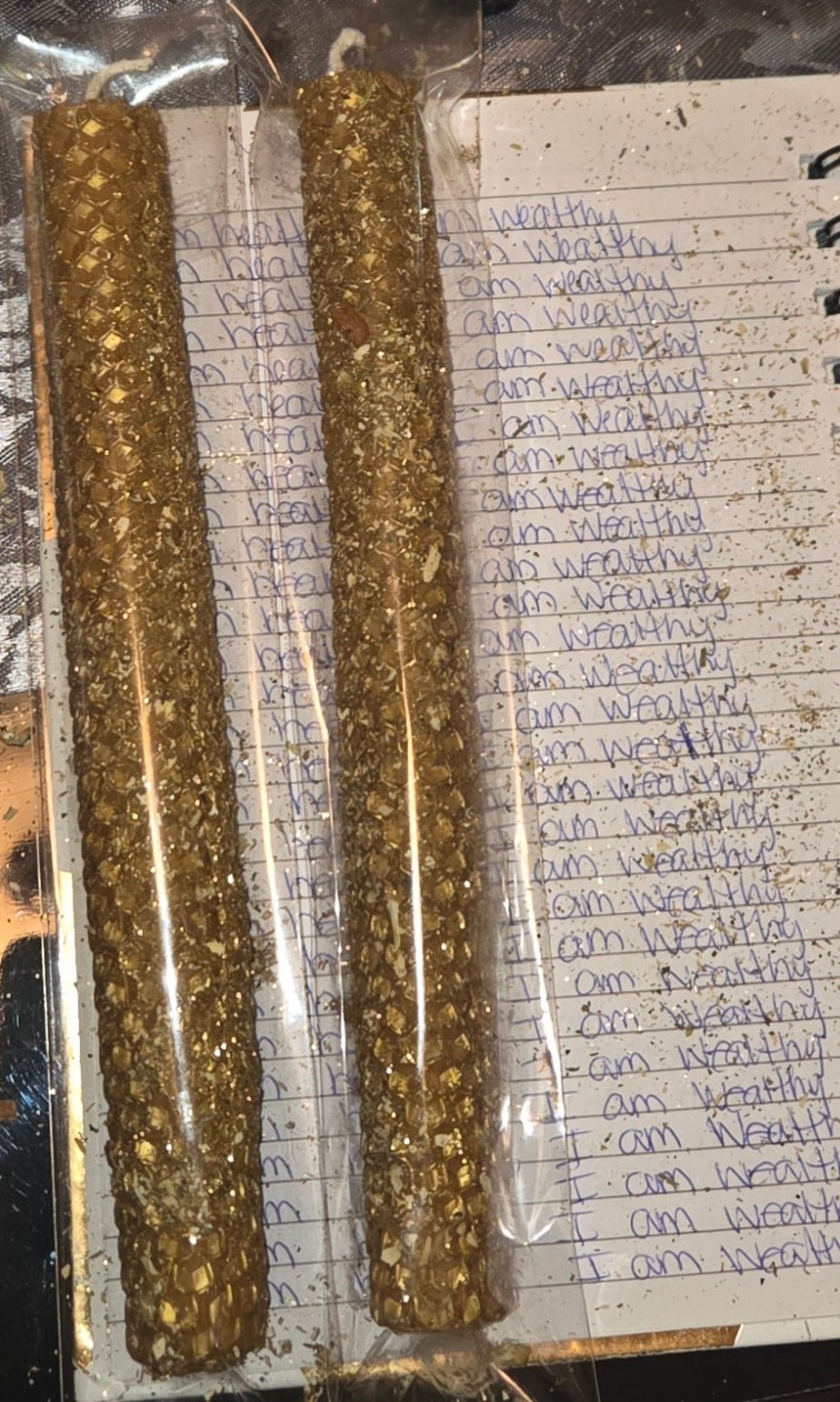 hand lighting beeswax honeycomb candle for wealth and abundance dressed in herbs