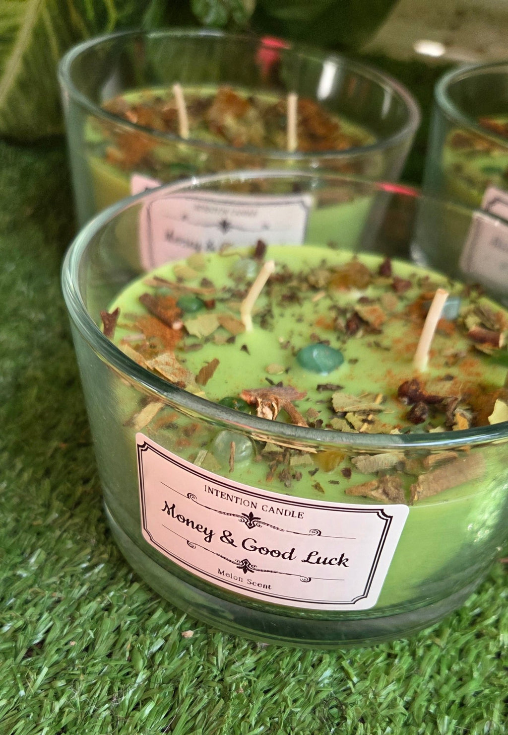 Money and good luck scented candle with herbs and crystals
